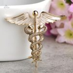 Accessoire en broche inspiré du caducée d'Hermès, design raffiné